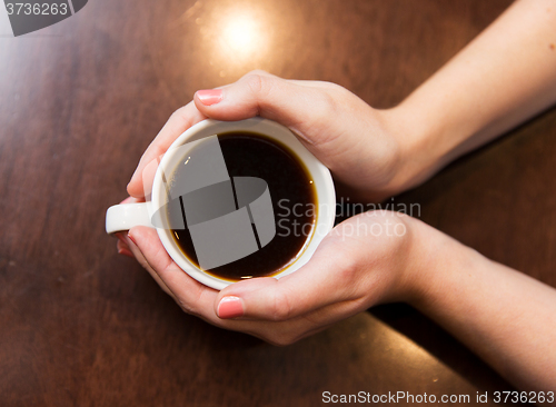 Image of close up of woman holding hot black coffee cup