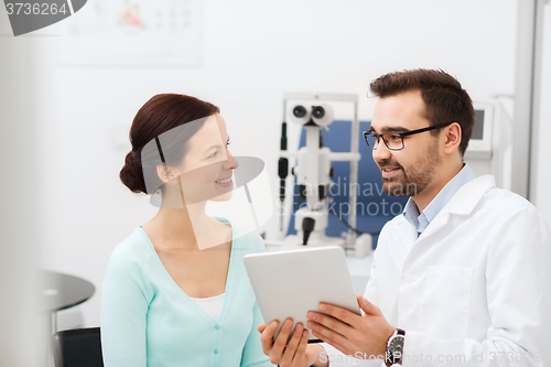 Image of optician with tablet pc and patient at eye clinic