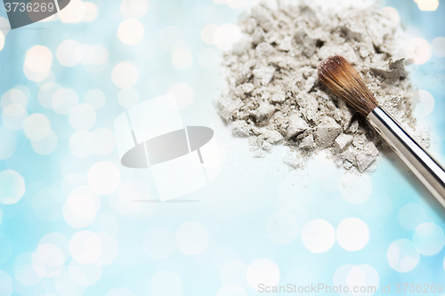 Image of close up of makeup brush and eyeshadow over lights