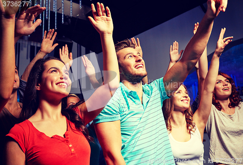 Image of smiling friends at concert in club