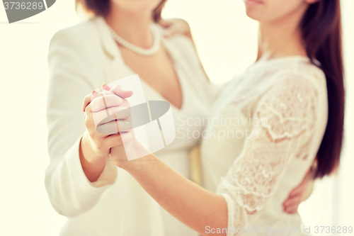 Image of close up of happy married lesbian couple dancing