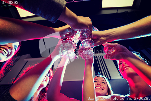 Image of smiling friends with glasses of champagne in club