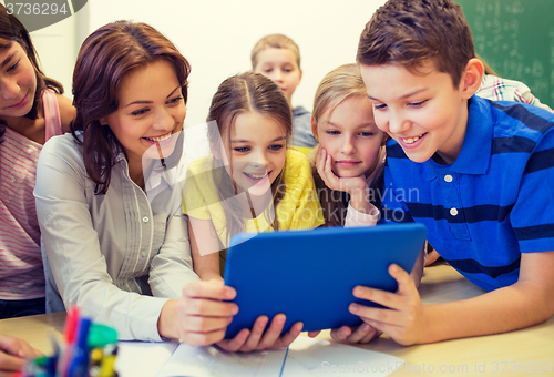 Image of group of kids with teacher and tablet pc at school