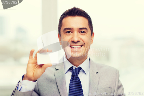 Image of smiling businessman in suit showing visiting card