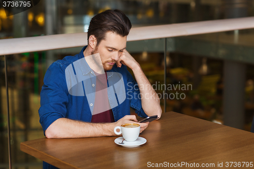 Image of man with smartphone and coffee at restaurant