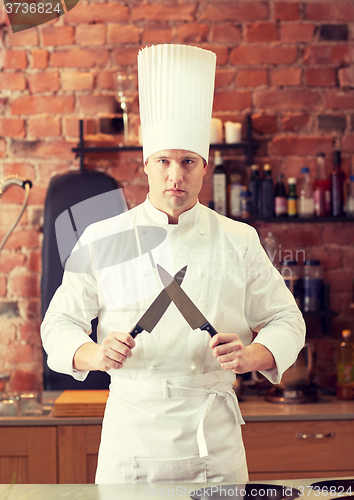 Image of happy male chef cook in kitchen with knife