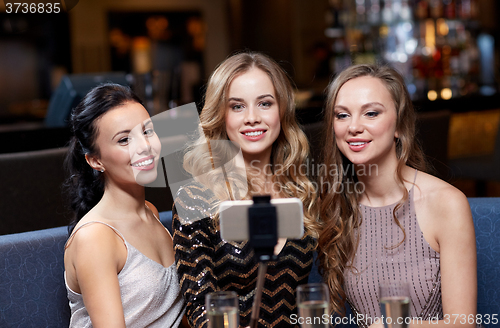 Image of women with smartphone taking selfie at night club