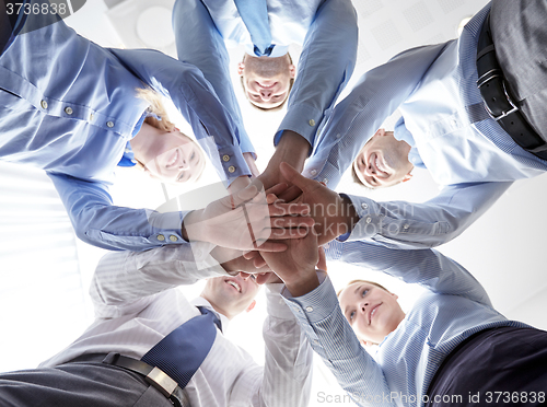 Image of smiling group of businesspeople standing in circle