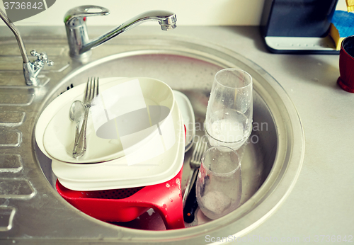 Image of close up of dirty dishes washing in kitchen sink