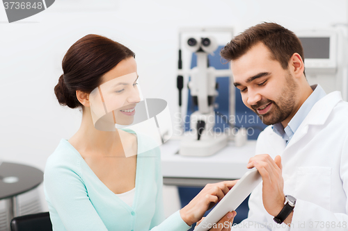 Image of optician with tablet pc and patient at eye clinic