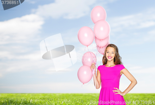 Image of happy young woman or teen with helium air balloons