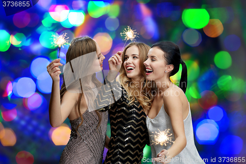 Image of happy young women with sparklers over lights