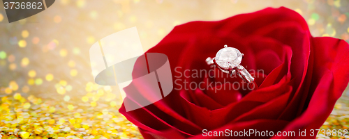 Image of close up of diamond engagement ring in rose flower