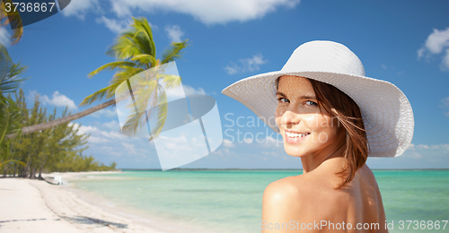 Image of happy young woman in sunhat over summer beach