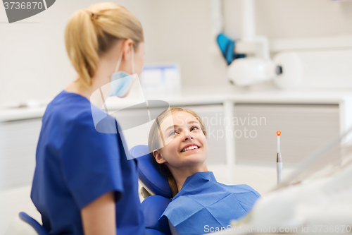 Image of happy female dentist with patient girl at clinic