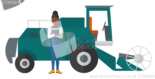 Image of Woman standing with combine on background.