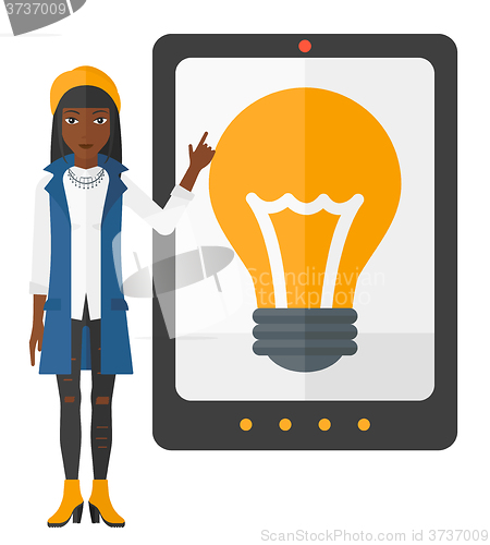 Image of Woman pointing at tablet computer with light bulb on screen.