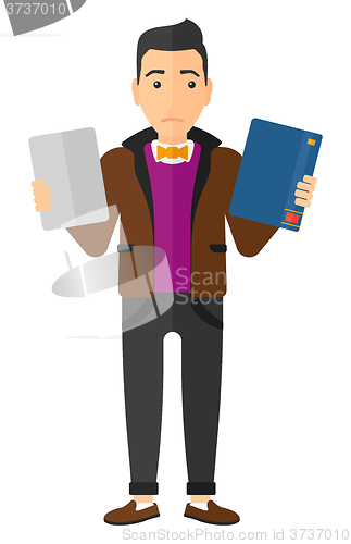 Image of Man choosing between book and tablet computer.