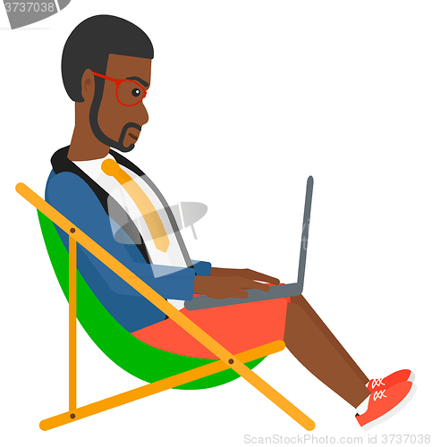 Image of Businessman sitting in chaise lounge with laptop.