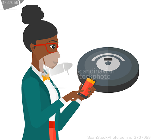 Image of Woman with robot vacuum cleaner.