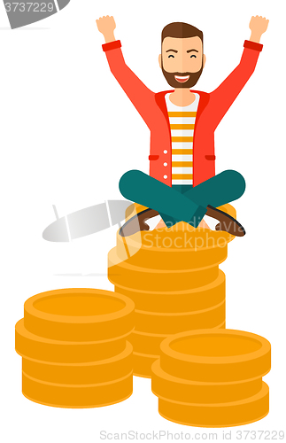 Image of  Happy businessman sitting on coins.