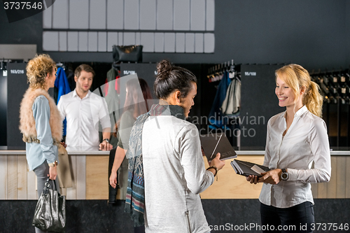 Image of Friends Standing By Bag Deposit Counter In Cafe