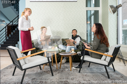 Image of Waitress Taking An Order From Customer In Cafe