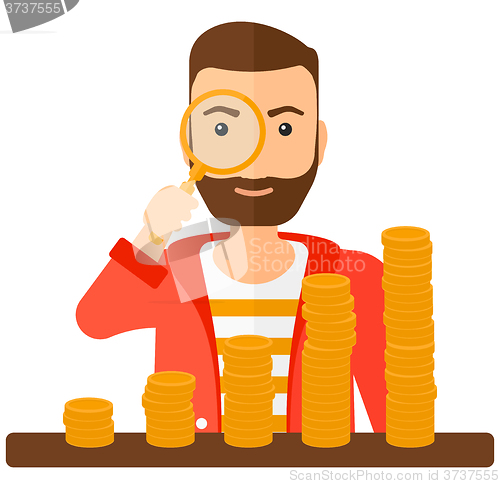 Image of Man with magnifier and golden coins. 