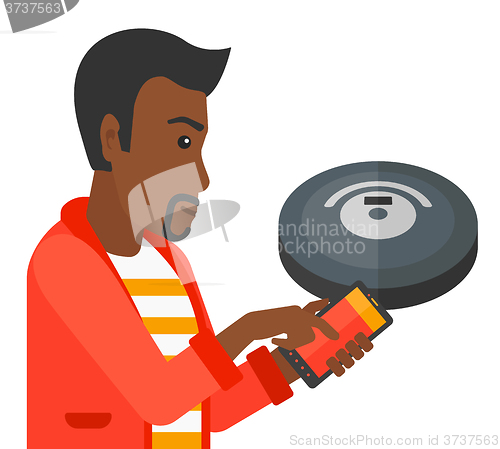 Image of Man with robot vacuum cleaner.