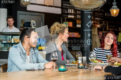 Image of Friends Conversing While Having Food At Restaurant