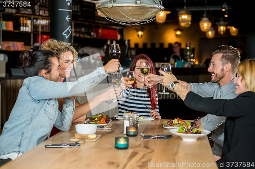 Image of Friends Toasting Wineglasses At Restaurant