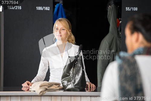 Image of Woman With Purse Standing At Bag Deposit Counter