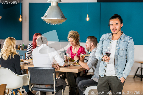 Image of Confident Man Holding Wineglass At Cafe