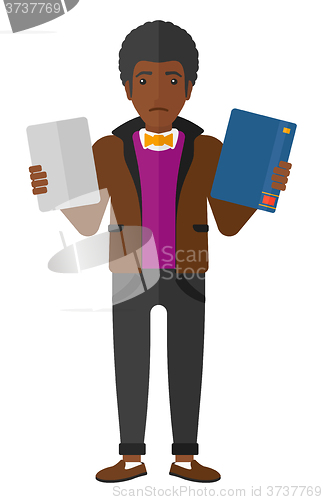 Image of Man choosing between book and tablet.