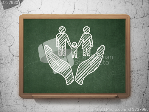 Image of Insurance concept: Family And Palm on chalkboard background