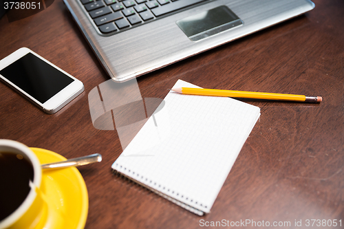 Image of close up of notebook with pencil and laptop