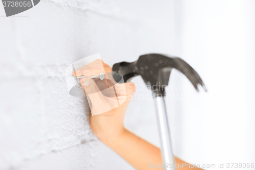 Image of architect hammering nail in wall