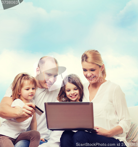 Image of happy family with laptop computer and credit card