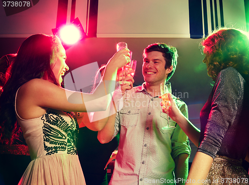 Image of smiling friends with glasses of champagne in club