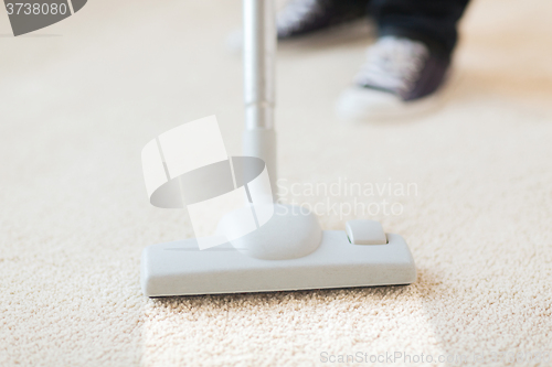 Image of close up of male hoovering carpet