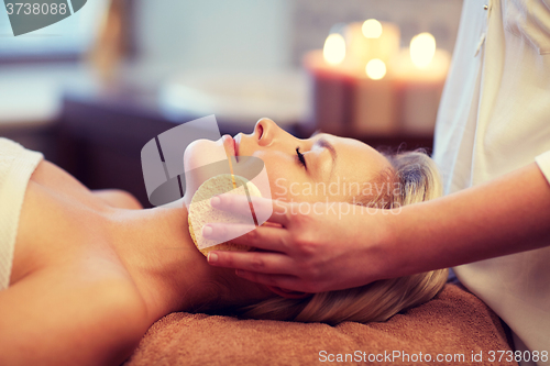 Image of close up of woman having face massage in spa