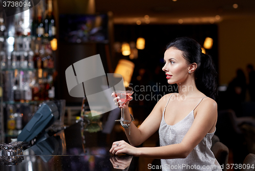 Image of glamorous woman with cocktail at night club or bar