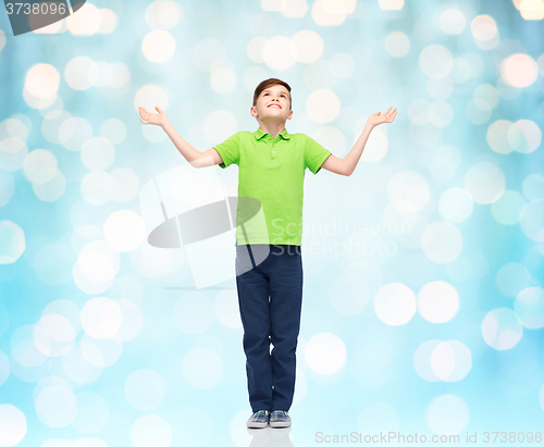 Image of happy boy in polo t-shirt raising hands up