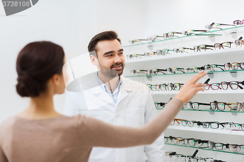 Image of woman showing glasses to optician at optics store