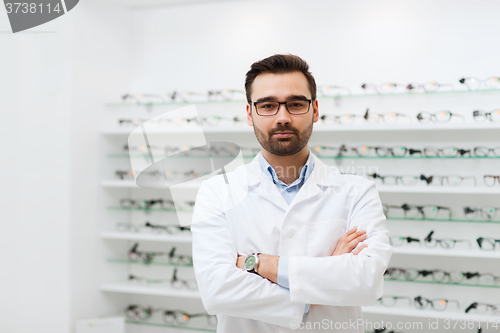 Image of man optician in glasses and coat at optics store