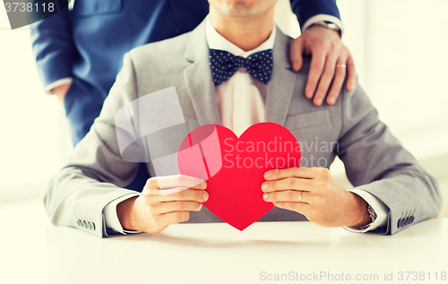 Image of close up of male gay couple with red heart