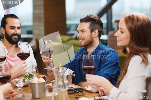 Image of friends dining and drinking wine at restaurant