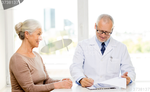 Image of smiling senior woman and doctor meeting