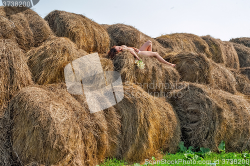 Image of Attractive nude woman relaxes on hay