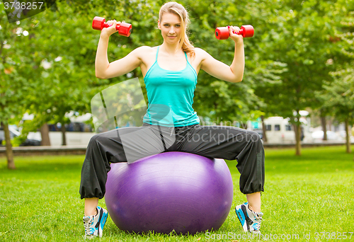 Image of Sports girl  exercise with dumbbells in the park